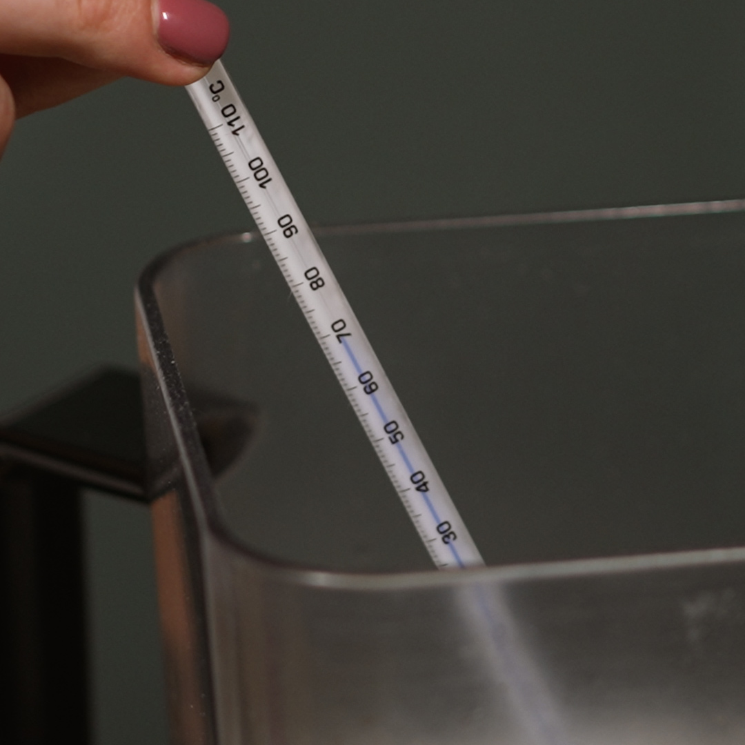 Das nectarbar Glasthermometer wird in einen Mixerbecher gehalten und zeigt 70 Grad Celsius.