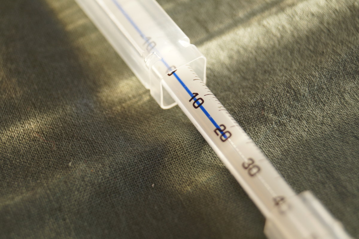 Detailansicht des Thermometer. Die Hülle ist geöffnet und ein Teil des Glas-Thermometers schaut heraus.